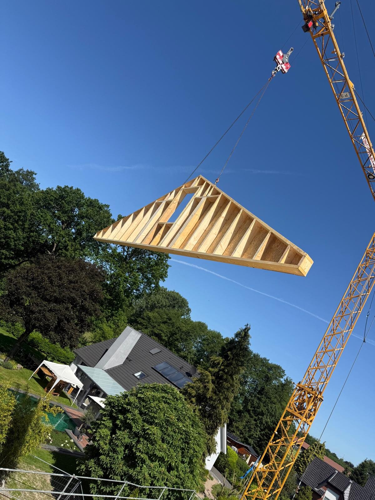 Vorgefertigtes Dachstuhlelement wird per Kran auf die Baustelle gehoben