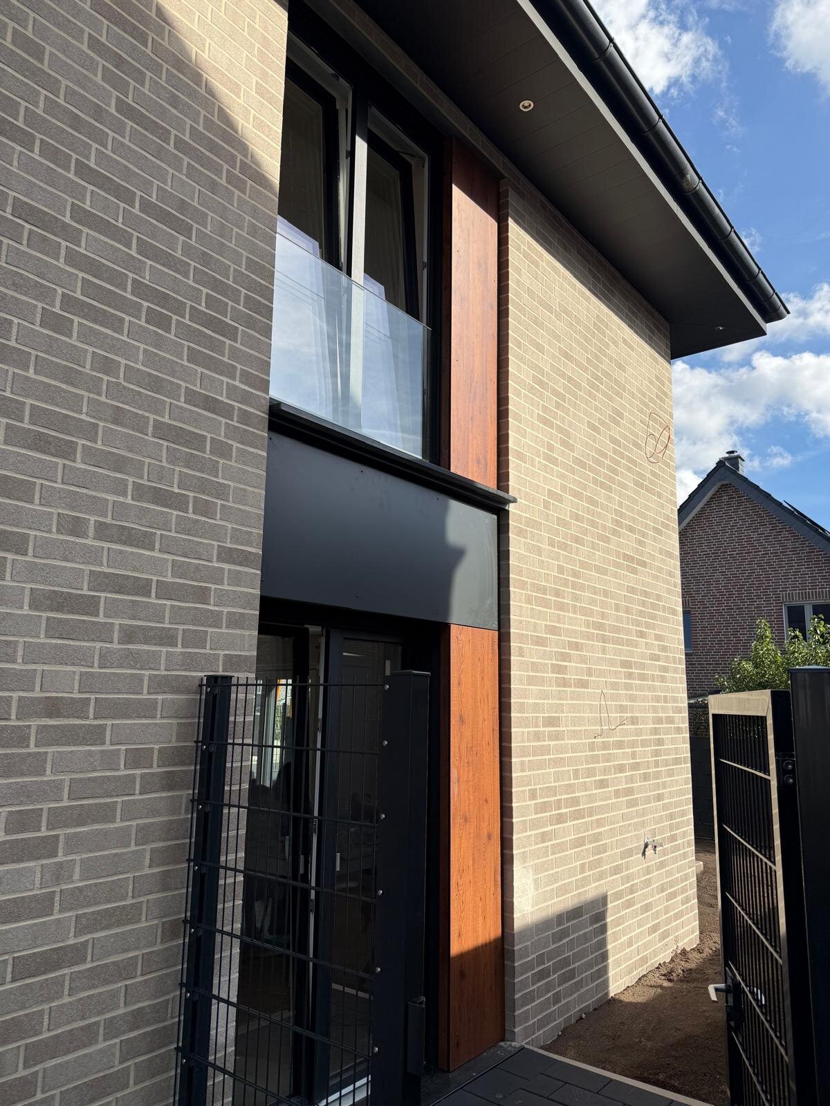 Fassadendetail mit HPL-Paneelen, Fenster und Metalltor