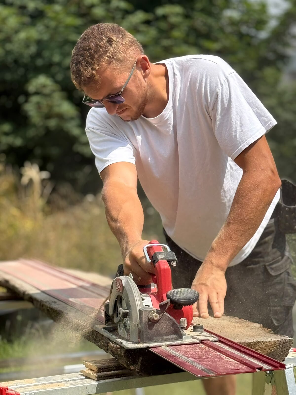 Handwerker von HolzWerk Albrecht beim Zuschnitt eines Holzbalkens mit der Handkreissäge